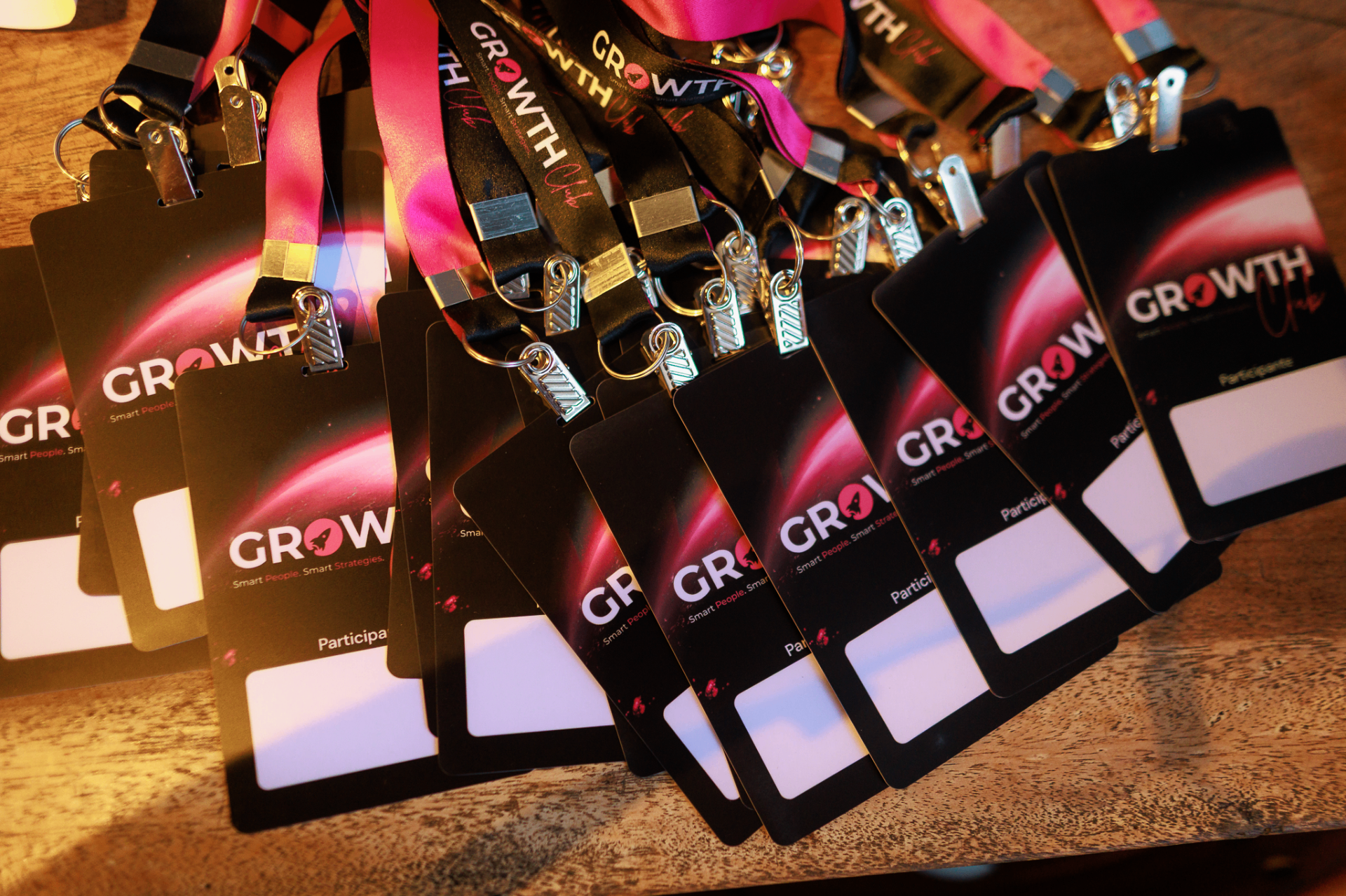 Crachás do GrowthClub com cordão rosa